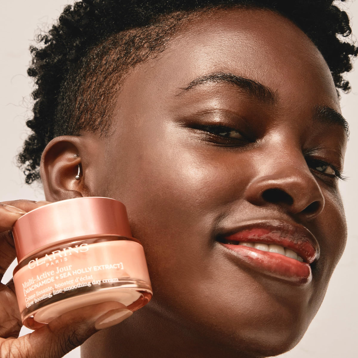 CLARINS jar held in hand for size comparison and travel-friendly benefit
