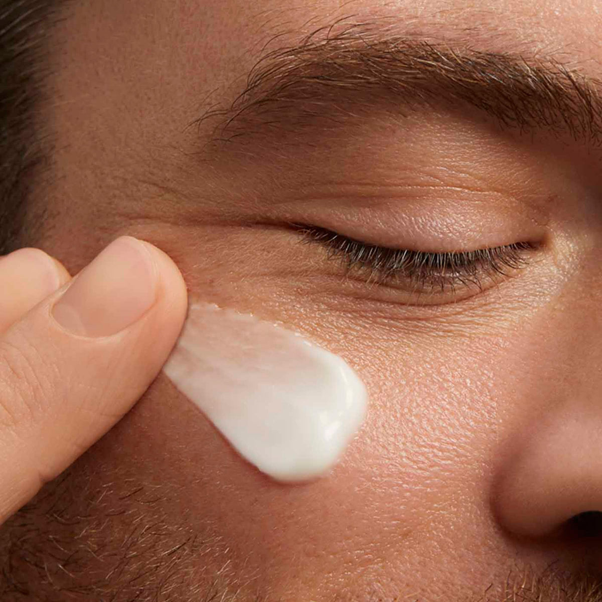 CLARINSMEN cream on fingertip illustrating easy spread and lightweight feel