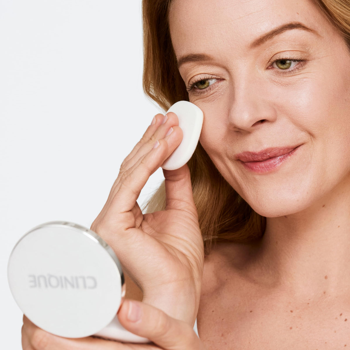 Clinique compact beside common items showing pocket-size convenience