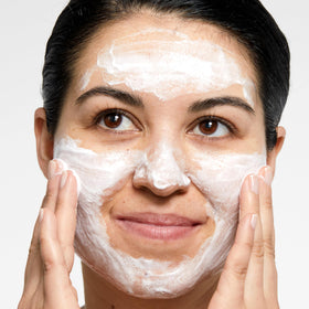Clinique bottle beside sunscreen and makeup showing thorough cleansing benefit