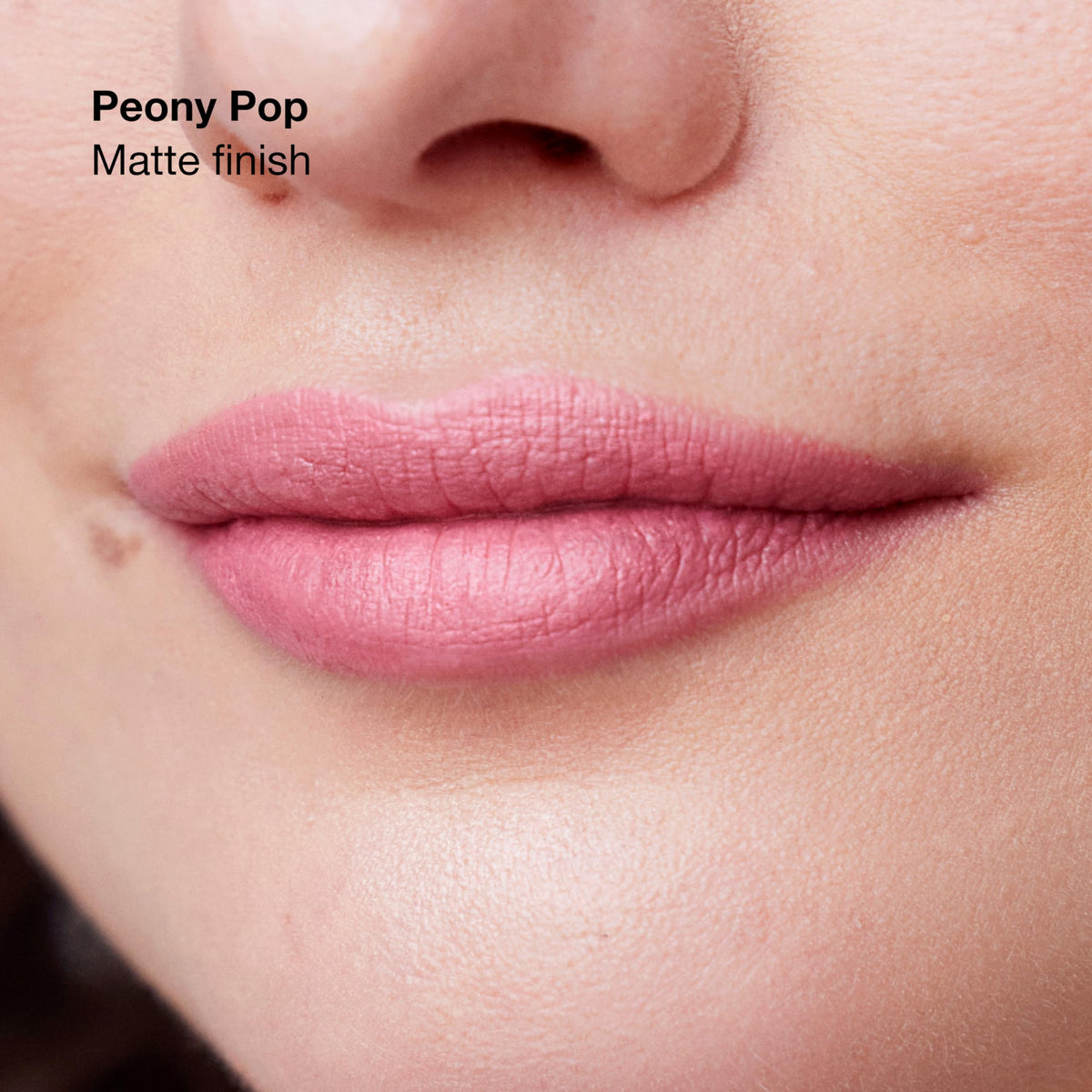 Clinique Peony Pop swatched on lips, demonstrates true-to-tint color and medium satin finish