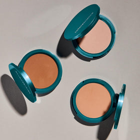 Colorescience compact beside a ruler showing size and Light Ivory shade comparison