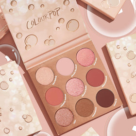 Vanity scene with ColourPop palette beside mirror showing stylish rosé looks at-a-glance