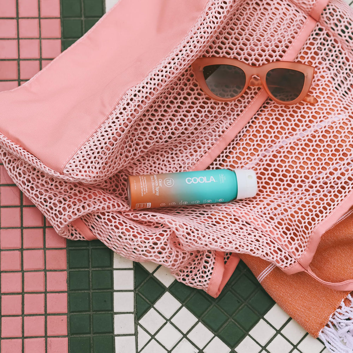 COOLA spray being applied from hand demonstrating quick, even coverage benefit