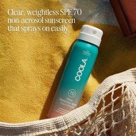 COOLA bottle on sand showing reef-compliant protection for beach days