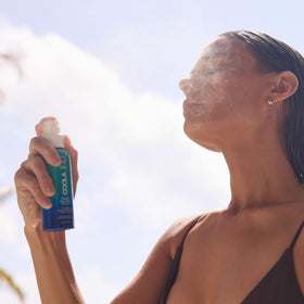 COOLA bottle held in hand showing travel-friendly 3.4 fl oz size for portability benefit