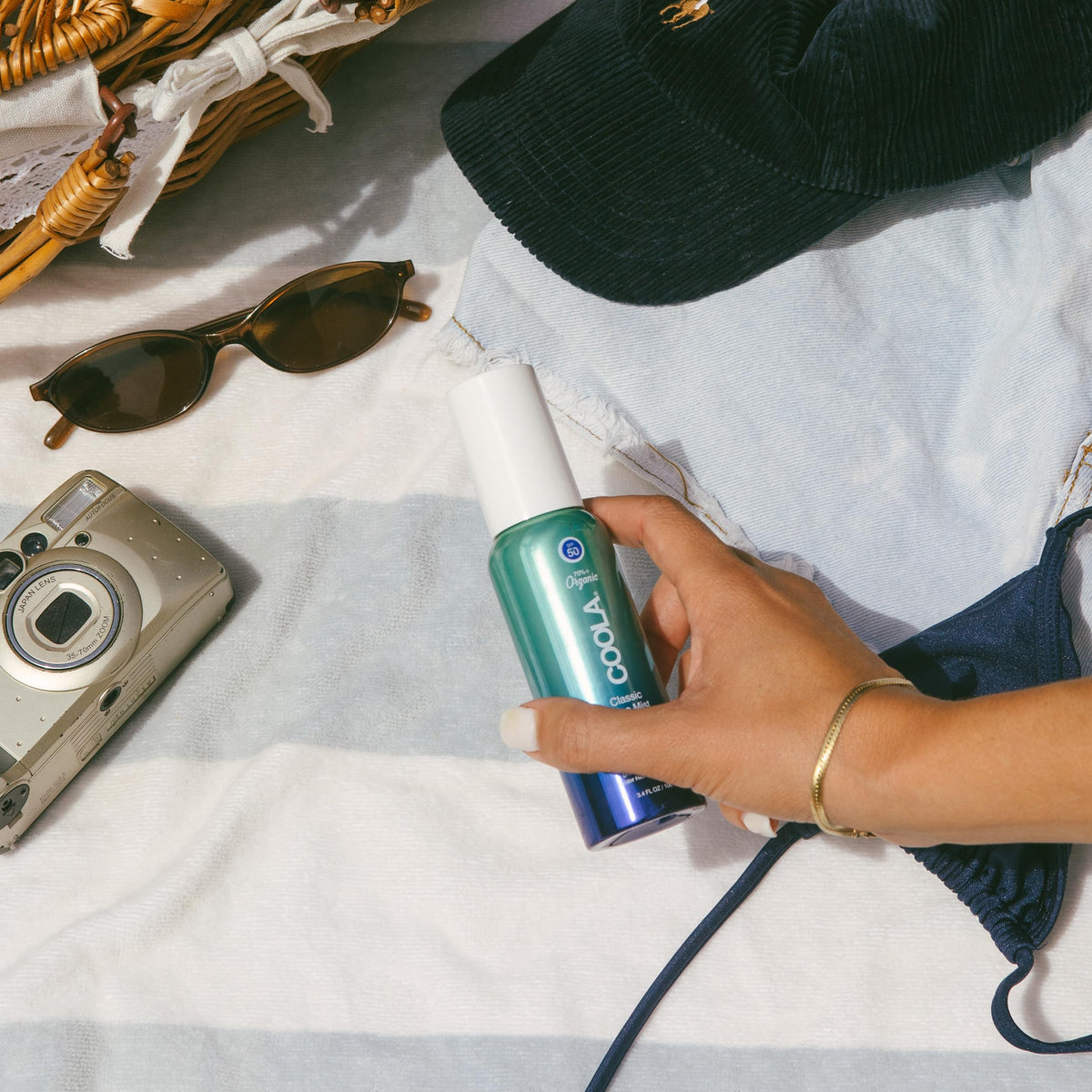 COOLA fine-mist texture visible in air demonstrating quick-drying refreshment benefit
