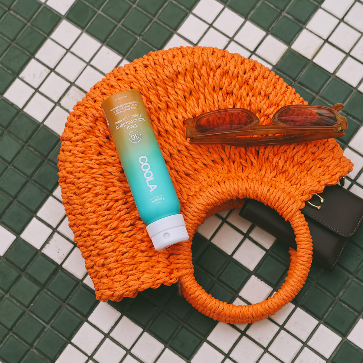 COOLA spray applied at beach illustrating water-resistant protection