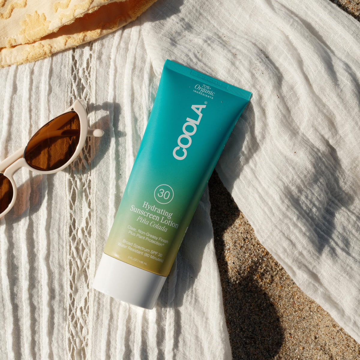 COOLA sunscreen in beach setting protecting skin during sunny outdoor activity