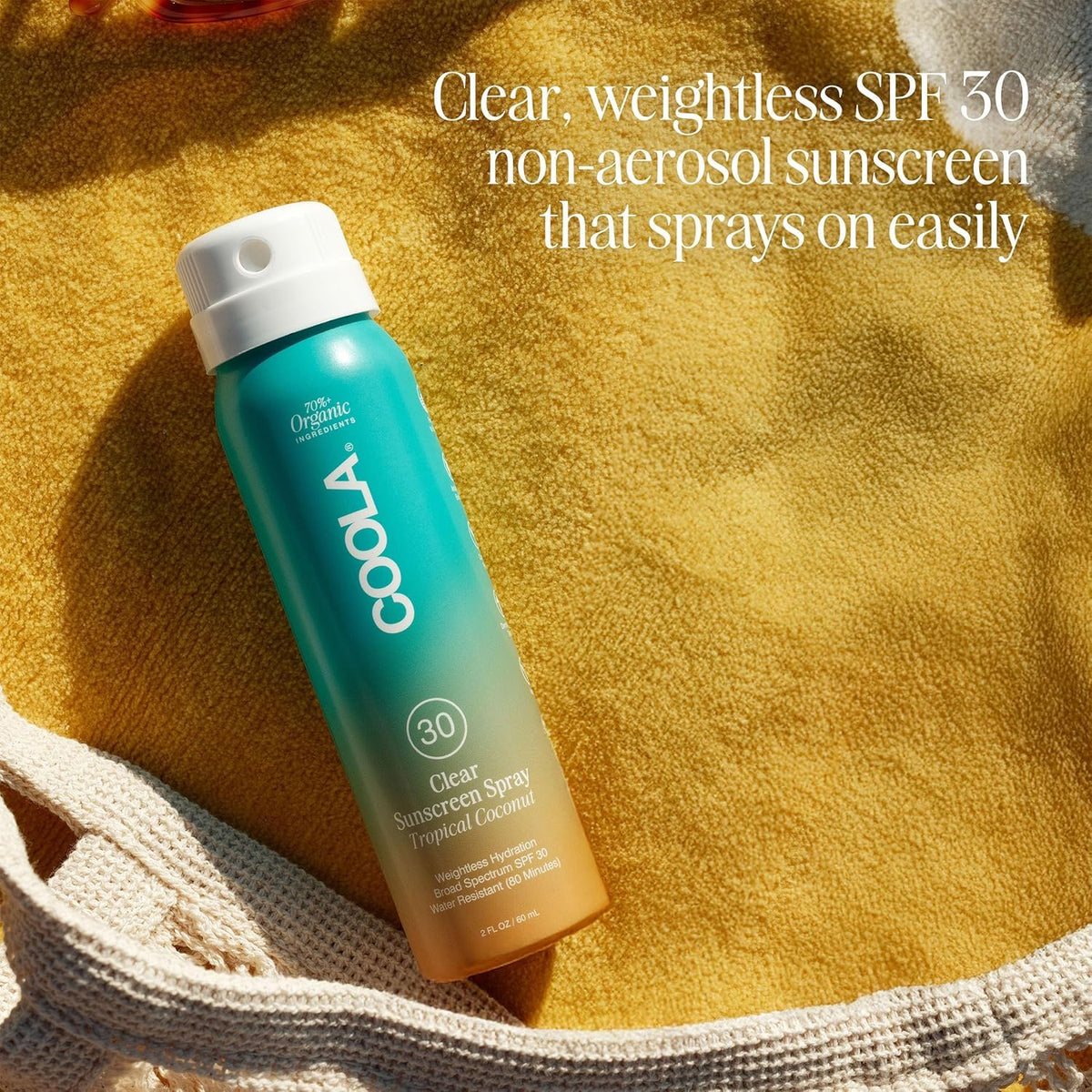 COOLA bottle next to hand showing 2 fl oz travel size convenience
