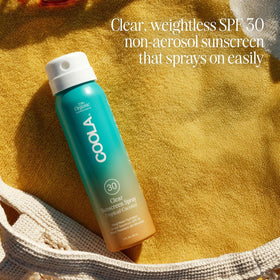COOLA bottle next to hand showing 2 fl oz travel size convenience