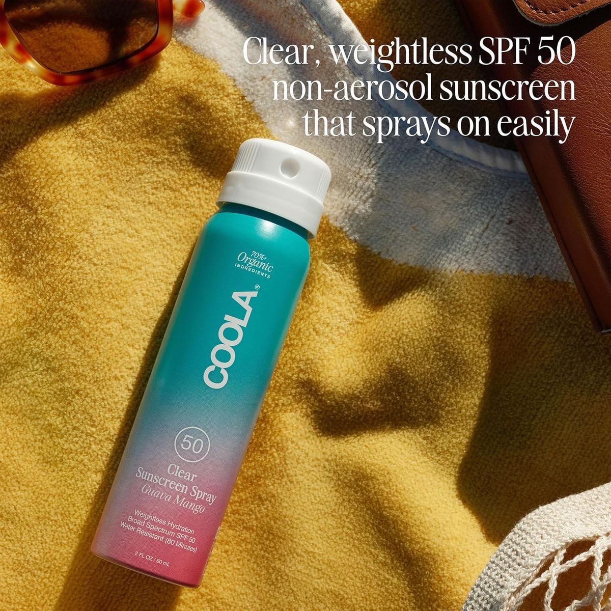 COOLA travel bottle in hand showing compact size and portability