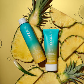 COOLA misting while upside down showing easy reach and even application