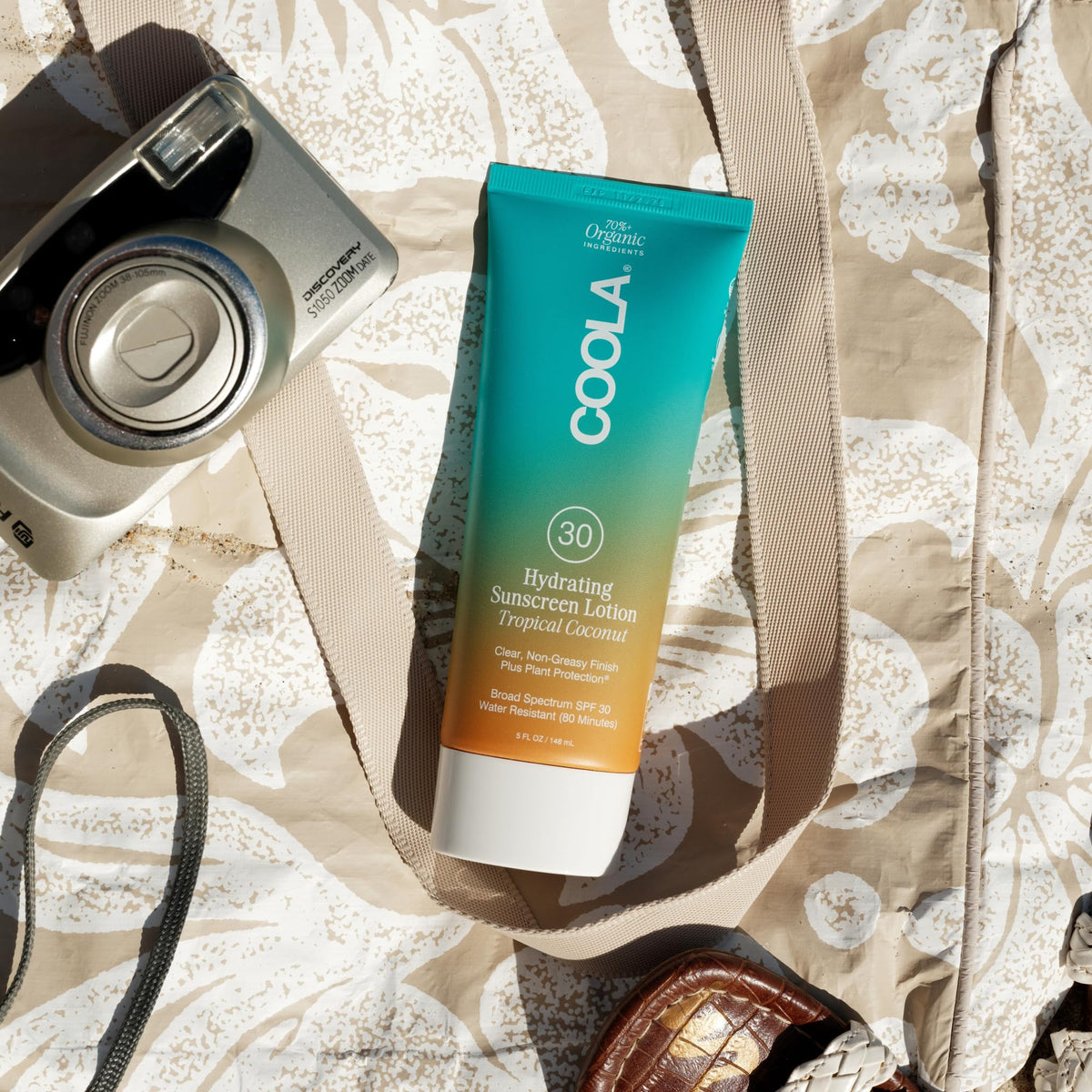 COOLA body lotion used at the beach for everyday sun protection benefits