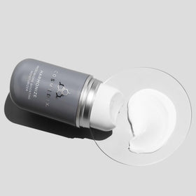 COSMEDIX Harmonize next to a coin to show compact size and portability