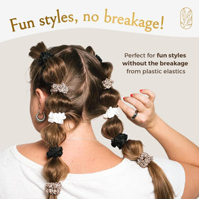Curlfriend Collective scrunchies on a nightstand beside pillow showing sleep-friendly low friction benefit