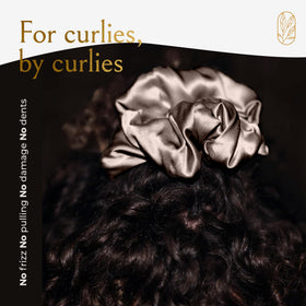 Curlfriend Collective scrunchie next to hand to show XL scale for thick or long hair