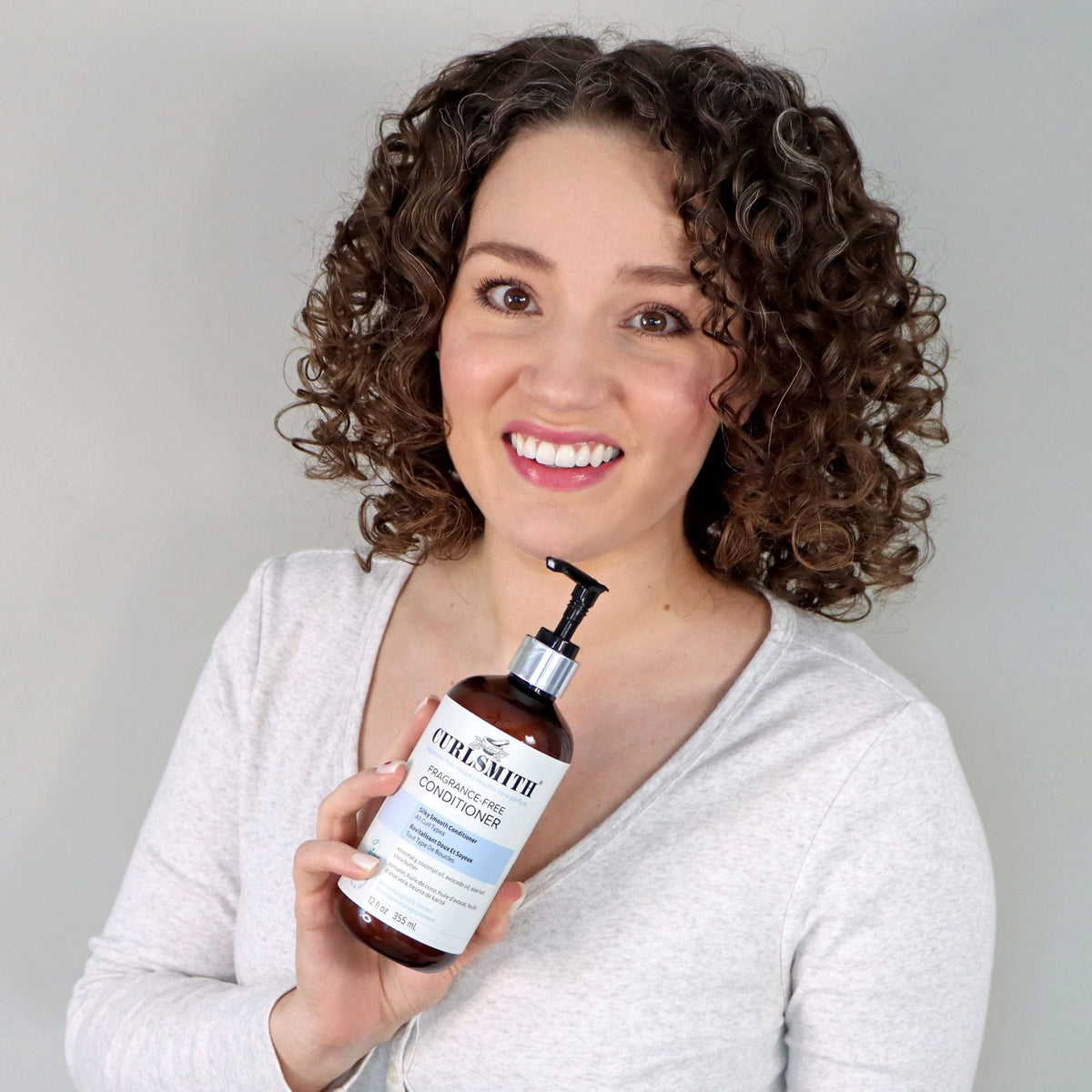 CURLSMITH product label close-up showing ingredients and dermatological testing benefit