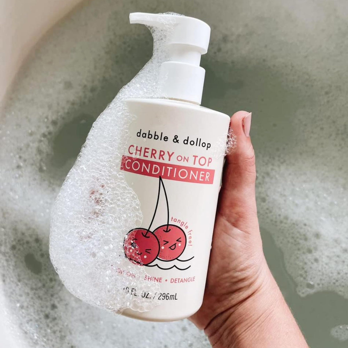 Dabble & Dollop child in bathtub using conditioner to make brushing easier