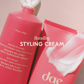 DAE applying cream to damp hair to prep for smoother blowout