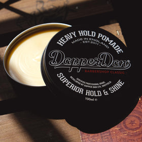 Dapper Dan pomade held in hand to show 100ml size and easy at-home use benefit