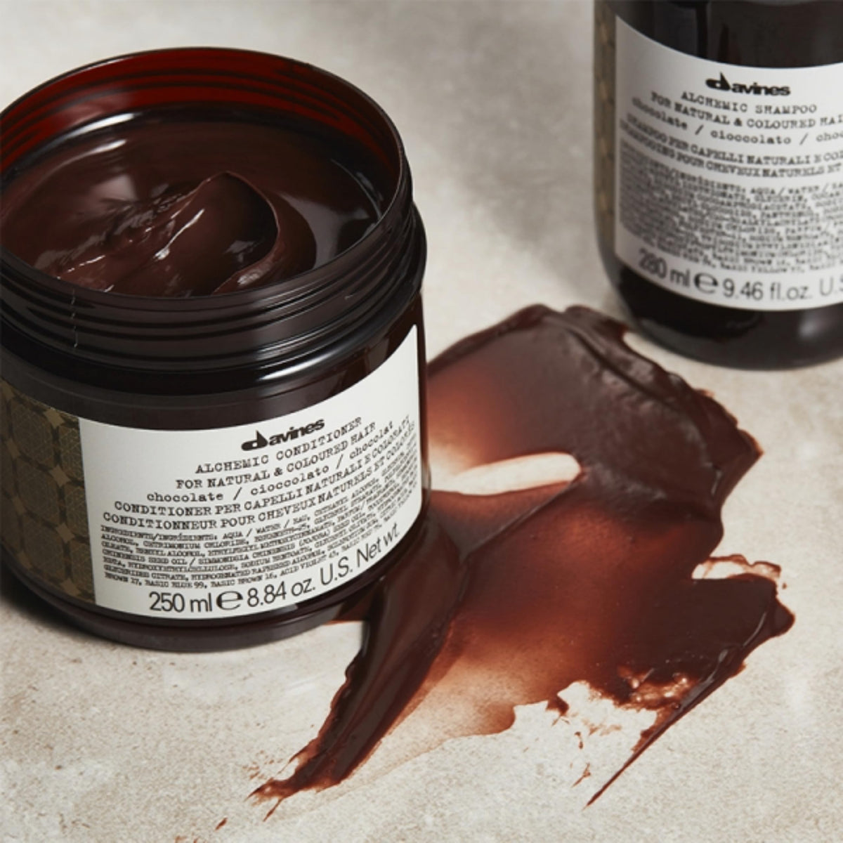 Hand holding Davines Alchemic Chocolate bottle showing true product size and portability