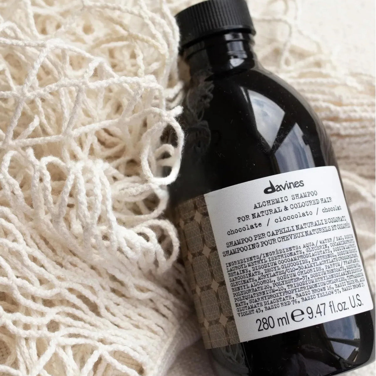 Davines bottle next to hand for scale showing compact 9.47 fl oz size