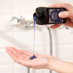 Davines Heart of Glass bottle on a travel vanity conveying portability and maintenance