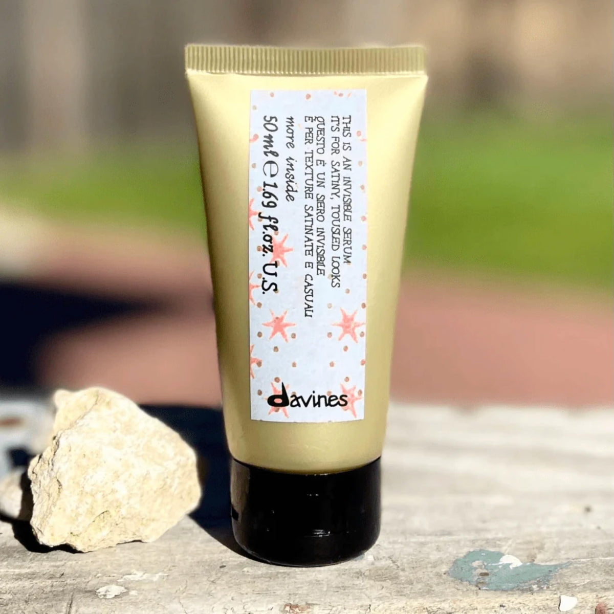 Davines bottle beside passport illustrating travel-friendly portable size