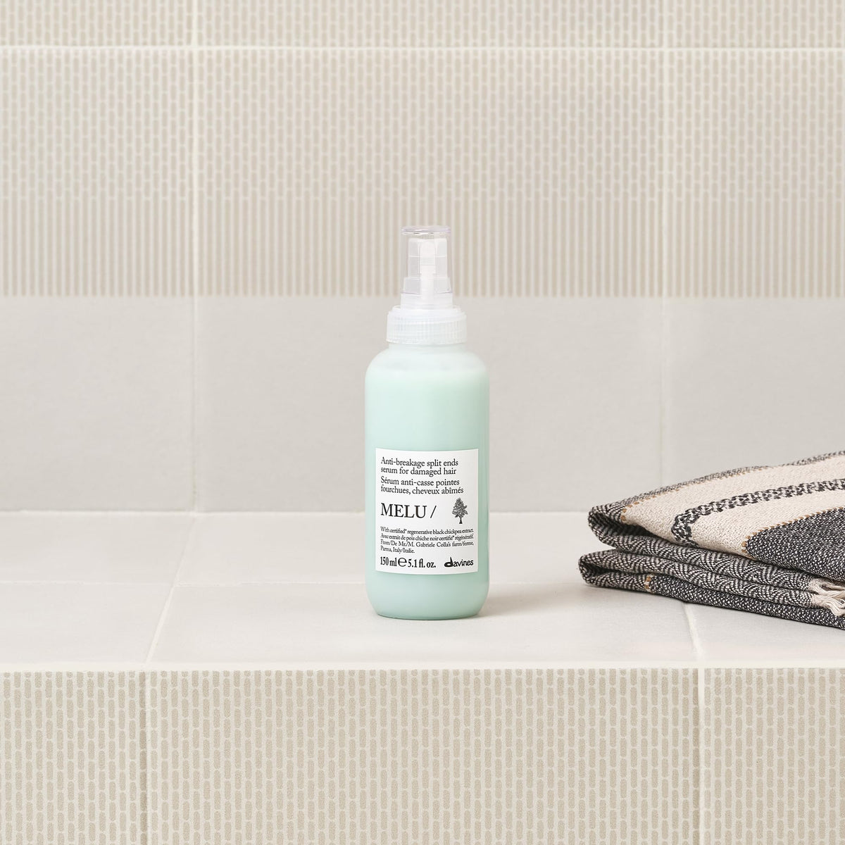 Davines MELU hands applying serum to hair ends for smoothing benefit