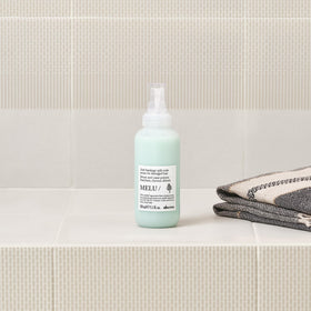 Davines MELU hands applying serum to hair ends for smoothing benefit