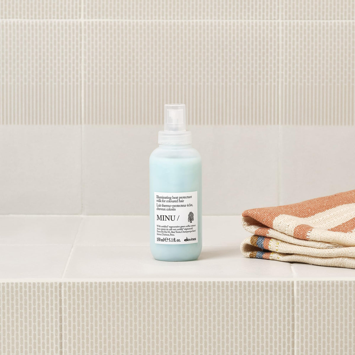 Davines MINU being spritzed on damp hair for detangling benefit