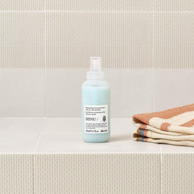 Davines MINU being spritzed on damp hair for detangling benefit