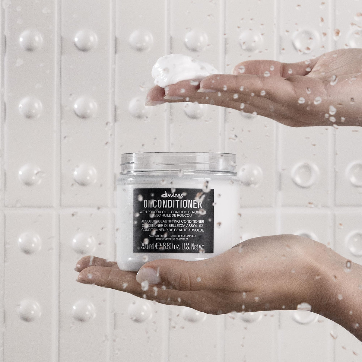 Davines products beside a hand to show scale and travel-friendly sizes benefit