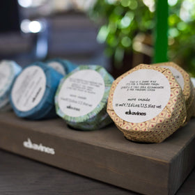 Davines shine wax next to a coin to show compact travel-friendly benefit