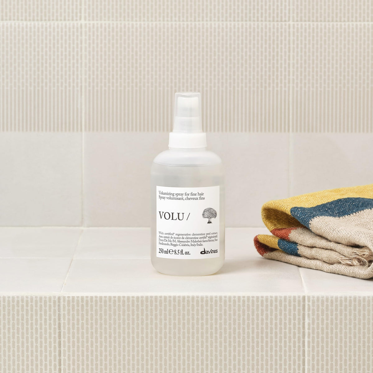 Model applying Davines mist at roots, creates natural full-bodied hair