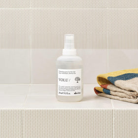 Model applying Davines mist at roots, creates natural full-bodied hair