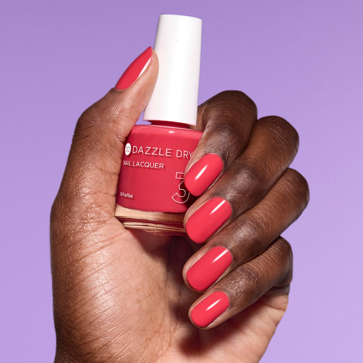 Dazzle Dry size comparison with hand to show 0.5 fl oz scale and portability