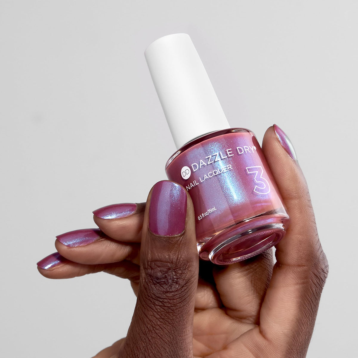 Dazzle Dry bottle held in hand showing size and 0.5 fl oz convenience benefit