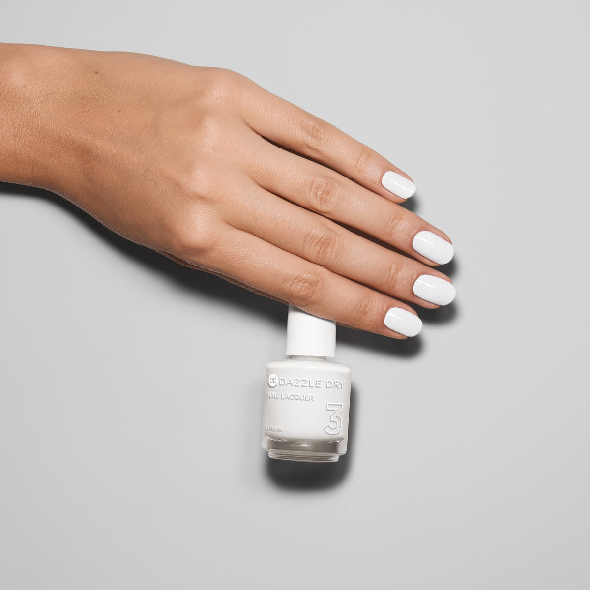 Dazzle Dry being applied to a natural nail demonstrating smooth, streak-resistant coverage