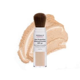 DERMA E compact beside sunglasses outdoors for on-the-go reapplication