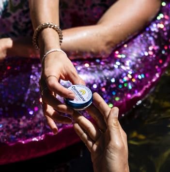 DERMATONE tin in hand to show compact size and travel convenience