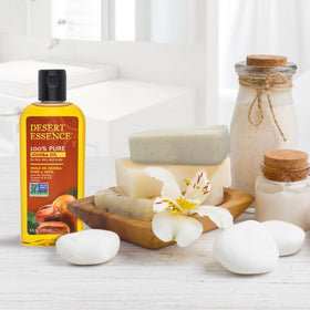 Desert Essence jojoba oil beside common toiletries to show 8 fl oz scale and value