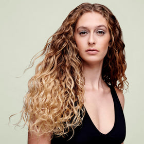 DevaCurl bottle in hand showing 32 oz scale and value