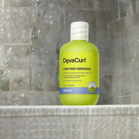 DevaCurl size comparison next to hand demonstrating 12 fl oz scale