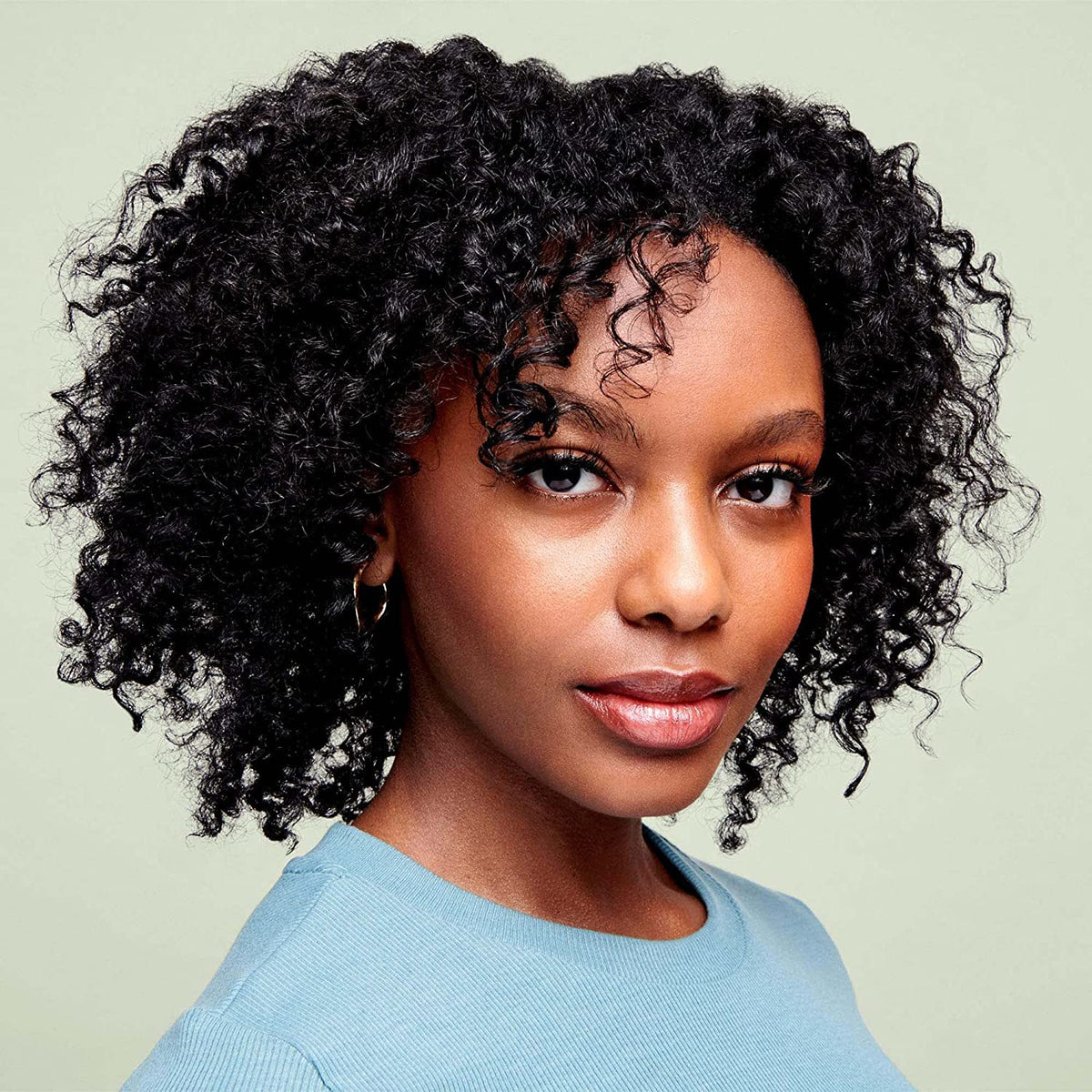 DevaCurl product in hand applied to wet hair for easier detangling