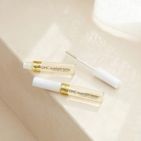 DHC eyelash tonic in nighttime routine setting showing restorative conditioning benefit