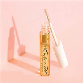 DHC eyelash tonic next to ruler for size scale comparison showing travel-ready benefit