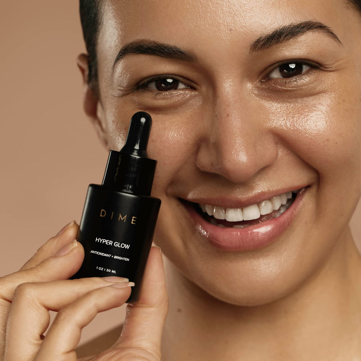 Applying DIME serum under makeup to demonstrate smooth layering benefit