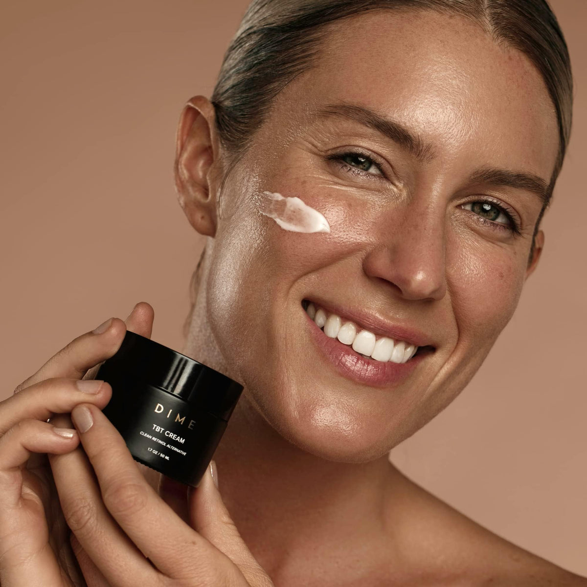 DIME TBT Cream being applied to cheek close-up showing lightweight absorption benefit